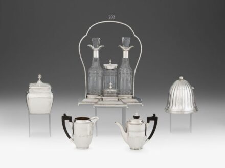 202. tétel, Pesti art deco fűszertartó készlet    Ezüst, 705 g. Golyó lábakon álló szögletes talapzat ívelt fogóval, hengerelt peremszéllel. Fúvott és csiszolt, eredeti üvegbetétekkel. Restaurált, egyik üvegbetétje hiányzik.     Jelzett: Pest, 1920 körül,