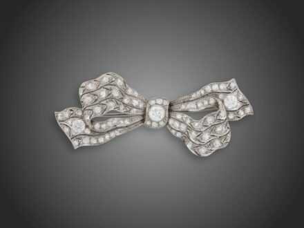 158. tétel, Melltű  Platina 950, szalagcsokorforma, 3 nagyobb régi csiszolású briliáns cca. 0,65 ct (R1CrSi) és 77 apró briliáns cca. 2,0 ct (R2CrP1) ékítéssel, 1930 körül, utólagos fémjelzéssel, 12,7 g