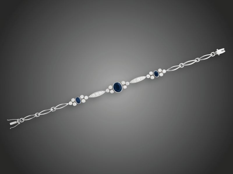 124. tétel, Karkötő  Fehérarany 585, 3 zafír 3,83 ct, 28 azsúrfoglalt briliáns 2,31 ct (MTrVs-Si) ékítéssel, 13,9 g, hossz: 20 cm