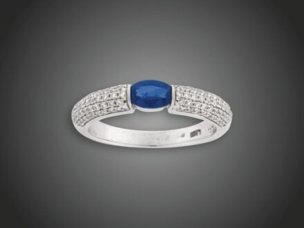 91. tétel, Női gyűrű  Fehérarany 750, 1 zafír cca. 0,50 ct és 102 apró pave foglalt briliáns cca. 0,60 ct (MTCrVs) gyűrűvállakon, 4,1 g, átmérő: 17,0 mm