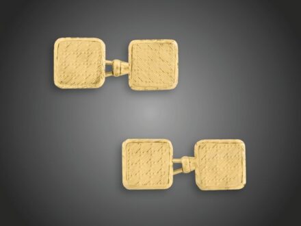 84. tétel, Kézelőgomb pár  Arany 580, szögletes formájú, gilosált díszítésű, karabiner kapcsolással, Pest, 1930 körül, 10,8 g