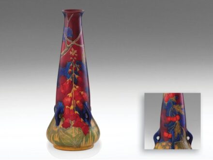 473. tétel, Zsolnay szecessziós díszváza  Korongozott és kézzel alakított fehércserép.   Opak, fémfényű és transzparens színes eozinmázas alapon kidomborodó, színes mázas cseresznyefa gyűszűvirágokkal. A kontúrokat bemélyítették, eozinmázakkal kihúzták, k