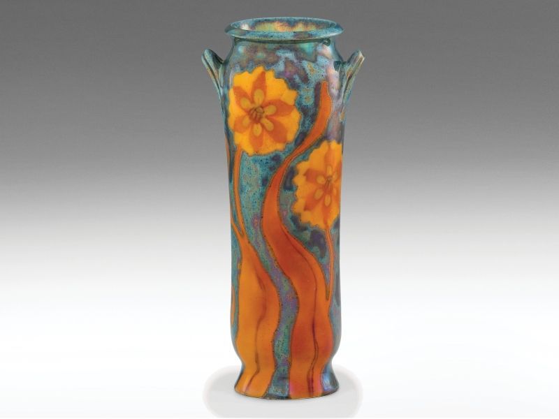 466. tétel, Zsolnay szecessziós díszváza   Fehércserép. Felületén selymesfényű, magas   tüzű színes -, és eozinmázakkal festett virágdísszel.   Alján jelzett: masszába nyomott 6815 (formaszám)   és alapmázzal megegyező kerek, domború, pecsétszerű márkajel