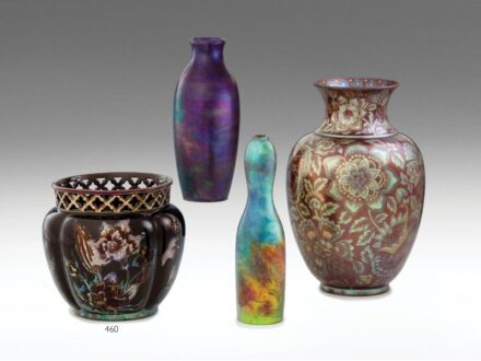 460. tétel, Zsolnay virágtartó díszedény  Formába öntött porcelánfajansz, áttört peremszéllel.  Felületén fémes fényű, színes mázakkal festett, kontúrrajzos orchideák.  Alján jelzett: eozinnal bélyegzett márkajelzés és keretben Made in Hungary.  Zsolnay,