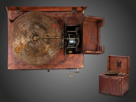 404. tétel, Zenedoboz  Nagyméretű hordozható Euphonion, 17 db.  50cm-es (19,5 coll) eredeti acéllemezzel. Működőképes.   Német, 1900 körül.  Feltehetően 1920-30 körül készült utólagos dobozán készítői jelzés: Balla Tibor Rádió villanyszerelési és mechanik