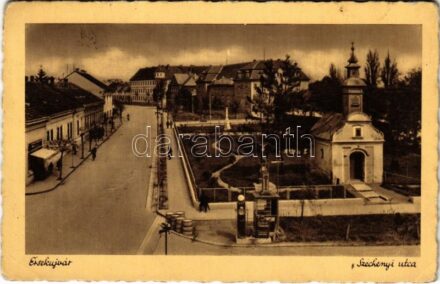 1940 Érsekújvár, Nové Zámky; Széchenyi utca, benzinkút, üzletek, templom. Jaksics Ferenc kiadása / street view, petrol pump, gas station, shops, church (EB)