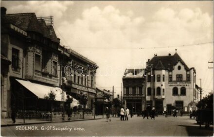 1930 Szolnok, Gróf Szapáry utca, Tiszavidéki Hitelintézet és Takarékpénztár rt., Phönix és Turul biztosító, Dusek Ferenc, Ford, Stühmer és Kádár üzlete, gyógyszertár, 'Lassan hajts' tábla (EK)