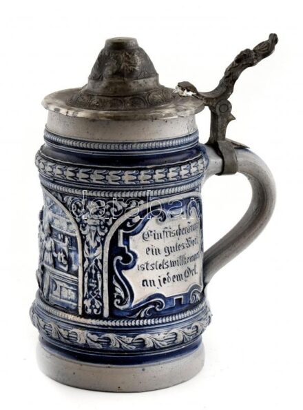 Német kerámia söröskorsó, domborműves díszítéssel, kissé deformálódott ón fedéllel, apró sérülésekkel, 0,5 l, m: 17 cm