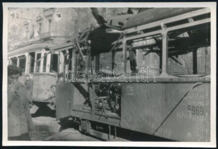 1956 Budapest, a harcok során kilőtt villamos a pesti utcán, oldalán érdekes feliratokkal, pl. 'köszönjük a szovjet nép ajándékát', fotó szép állapotban, 8×12,5 cm