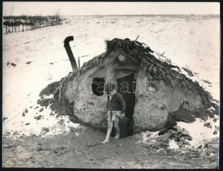 1977 Cigány fiú egy földbe vájt vályogkunyhó előtt, Révász Tamás fotóművész könyvében (Búcsú a cigányteleptől, Kossuth, 1977) publikált fotója, hátoldalon merevítőpapírral, 18×23,5 cm
