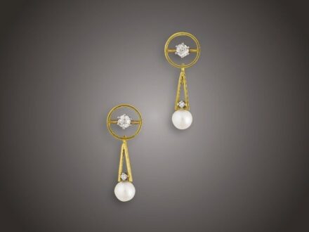 Fülbevaló pár
Arany 750, karikaforma, közepében 2 karmos foglalású
régi csiszolású briliáns cca. 0,40 ct (R2CP1), 2 gyöngyös
levehető csüngővel és 2 apró achtkant csiszolású briliáns
cca. 0,02 ct ékítésel, csavaros szereléssel, 7,6 g