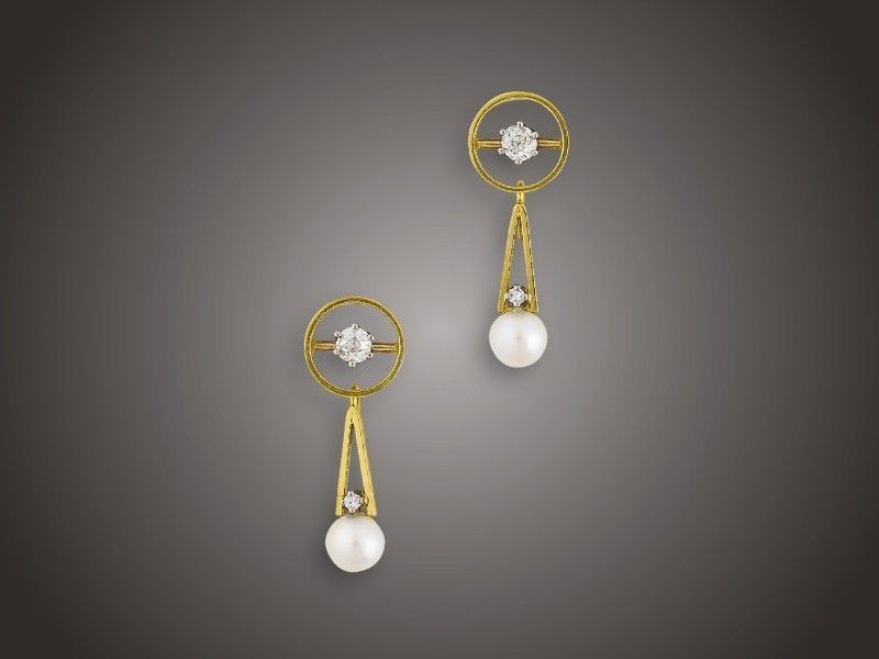 Fülbevaló pár
Arany 750, karikaforma, közepében 2 karmos foglalású
régi csiszolású briliáns cca. 0,40 ct (R2CP1), 2 gyöngyös
levehető csüngővel és 2 apró achtkant csiszolású briliáns
cca. 0,02 ct ékítésel, csavaros szereléssel, 7,6 g