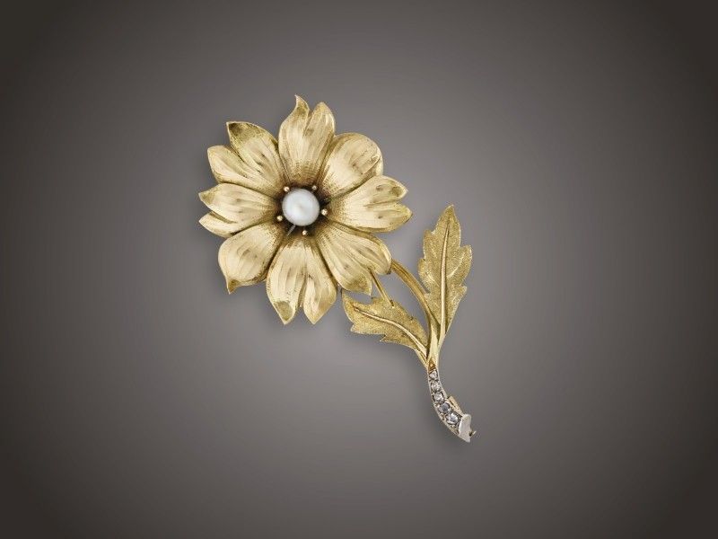 Melltű
Arany 585, plasztikus virágforma, közepében 1 tenyésztett
gyöngy, szárvégen 5 különböző nagyságú, rózsacsiszolású
gyémánt cca. 0,10 ct ékítéssel, Budapest, 1940 körül, 13,1 g
