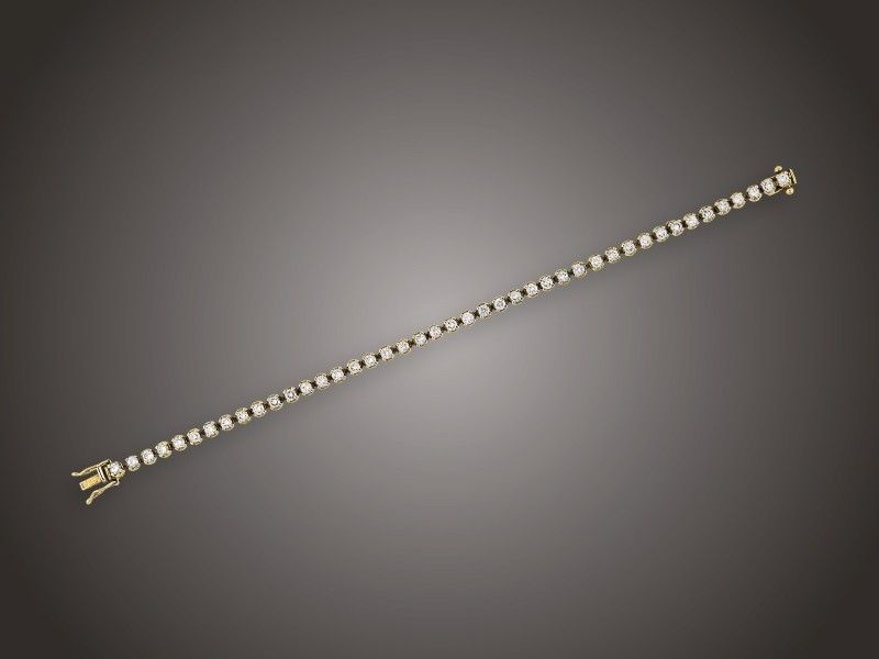 Karkötő
Arany 750, keskeny sorban 43 karmos foglalású briliáns
cca. 2,60 ct (MCrSi) ékítéssel, nyelves zárral, 2 biztonsági
nyolcassal, 12,5 g, hossz: 17 cm