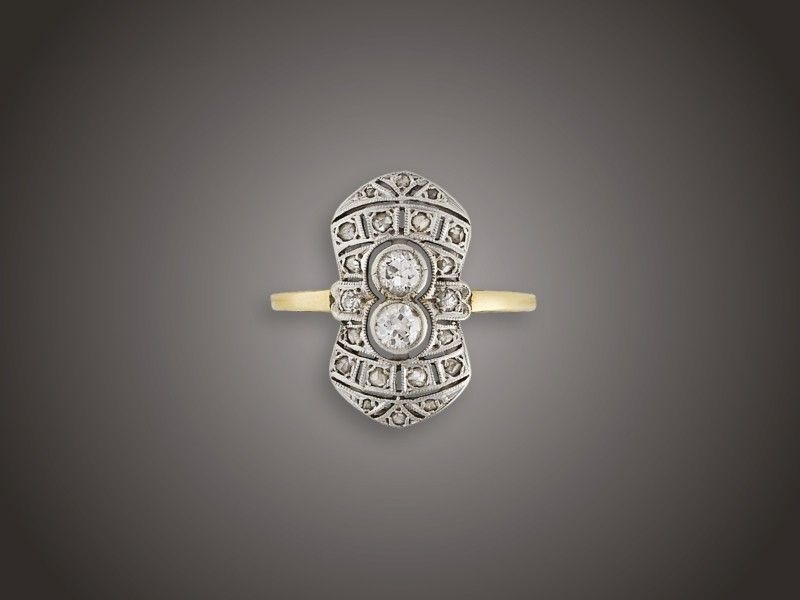 Női gyűrű
Arany 585, hosszúkás, geometrikus stílusú fejen 2 régi
csiszolású briliáns cca. 0,35 ct (R2CrP1) és 20 apró
gyémánt cca. 0,15 ct ékítéssel, 1930 körül, után fémjelzett,
4,3 g, átmérő: 18,0 mm