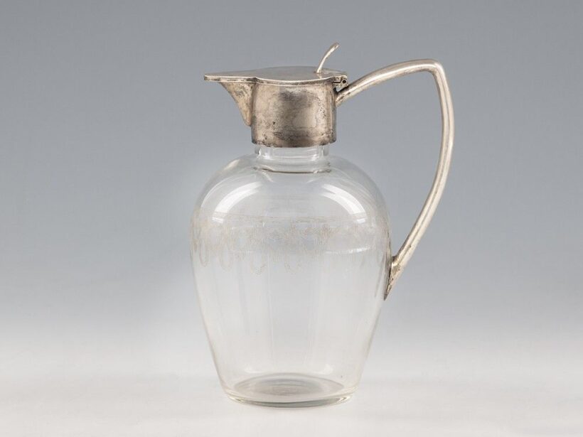 Karaffa_x000D_
Fúvott, színtelen üveg köszörült díszítéssel, ezüst füllel és billenőfedéllel._x000D_
Jelzett: Bécs, 1910 körül, Lippa & Co._x000D_
M.: 18 cm
