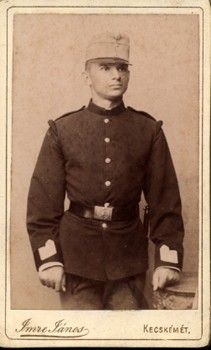 Imre János kecskeméti fényképész műtermében készült keményhátú fotó.  Imre János kecskeméti fényképész műtermében készült keményhátú fotó. Vizitkártya. Katona. 1870-es évek.
