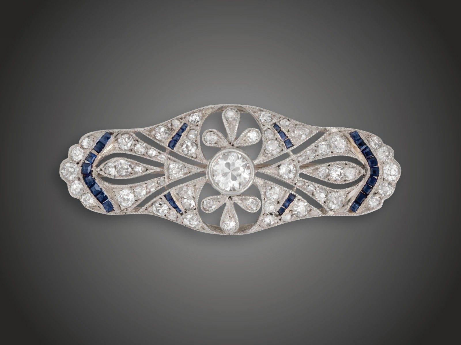 Melltű, 585 au, 60 bril., gyém. cca. 0,90 ct, zafír, 3,6 g