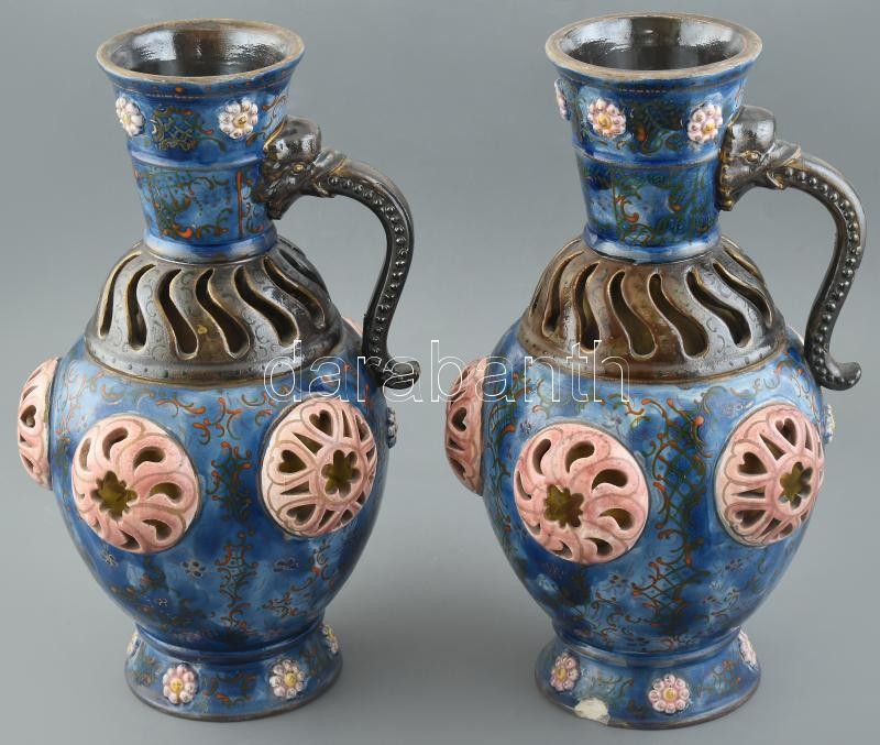 Fischer díszkancsó-pár. Formába öntött porcelánfajansz, dupla falú áttört díszítéssel. Felületén kidomborodó, áttört medalionok és színes zománccal festett keleties virágdekor. Talpperemeken tűzrepedés, néhány részén,