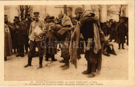 Ankunft Schwerverwundeter vor einem Feldlazarett in Sejny. Im Vordergrund ein Russe mit einem deutschen Soldaten auf dem Rücken / Súlyosan sérült katonák tábori kórházba érkezése / WWI German military, arrival of the seriously wounded at