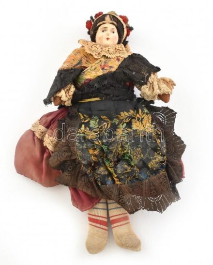 Népviseletes porcelán fejű baba, szakadozott ruhával, m: 34 cm