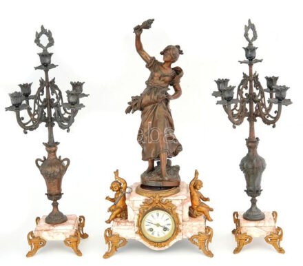Kandallóóra kandeláber párral. Francia, cca 1900, márvány, spiáter, bronz, órán puttó figurákkal, porcelán számlap, előtte fazettált üveg. Az aratónő szobra Auguste Moreau (1834-1917) munkája után készült. Felesütős szerkezet, kulccsal. Öt gyertyacsészés kandeláberpár. Néhol kopott felületekkel, kandeláber egyik karja sérült, m: 63 cm /// KIZÁRÓLAG SZEMÉLYES ÁTVÉTEL, NEM POSTÁZZUK / ONLY PERSONAL COLLECTION IN OUR