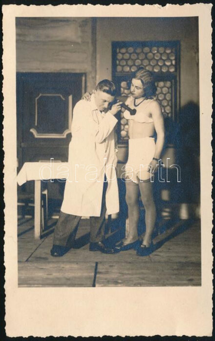 cca 1930 Homoerotikus jelenet: nőnek öltözött, fehérneműt és parókát viselő férfi "orvosi vizsgálaton". Fotólap, jelzés nélkül, 13,5x8,5 cm // cca 1930 Homoerotic scene: a man dressed as a woman, wearing lingerie and a wig, is undergoing "medical examination". Photo postcard, unmarked, 13.5x8.5