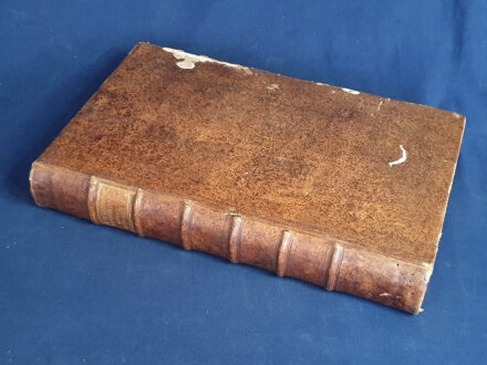 [Bonbardi] Bonbardus, Michael: Topographia magni Regni Hungariae olim a P. Michaele Bonbardio, e Societate Jesu conscripta; nunc vero opera et studio Joannis Bapt. Trsztyánszki ex eadem Societate emendata et Aucta. [Bécs] Viennae Austriae, 1750. Prostat apud Leopoldum Kaliwoda et Augustinum Bernardi. [8] + 590 + [12] p. Folio. Példányunk címlapvariáns, egy tervezett topográfiai sorozat első kötete, melyből több nem jelent meg. A címlap szedése is jelentősen eltér az általában előforduló példányok címlapjától, ebbe a variánsba a Mária Teréziát ábrázoló allegorikus címképet, valamint a címlapot követő, neki szóló ajánlást nem kötötték bele. Michael Bonbardi (1683-1729) jezsuita szerzetes munkája Magyarország topográfiájának leírása, a valaha itt élt és élő összes nép (hunok, avarok, vandálok, németek, magyarok, szlovákok, románok, illírek, kunok) rövid történetének összefoglalásával. A megfelelő földrajzi fejezetekben a szerző a közelmúlt hatalmi helyzetét meghatározó okiratokat és levelezést is betűhíven közli: Pilis megye leírásában Lipót császár diplomáját, Széchényi György esztergomi érsek levelét, Baranya vármegye leírásában - humanista adalékként - Janus Pannoniust idézi, másutt pedig egyéb emlékezetre méltó dolgokról emlékezik meg: Pozsony vármegyénél a dús kerteket méltatja, Nagyszombatnál a jezsuitákat. Jóllehet a jezsuita szerző bécsi perspektívája miatt elsősorban a Dunántúl és a Felvidék megyéiről szól bőven, így Erdély ismertetését teljesen mellőzi, az Alföld topográfiai bemutatása pedig csupán pár rövid fejezetre korlátozódik, ennek ellenére fontos kiemelni, hogy a jászkun kerület jellemzésénél elsőként ismerteti a manapság ugyan közismert, akkoriban viszont elfeledettnek számító Lehel-mondát. A mű első kiadása 1718-ban jelent meg, tételünk a munka 1750. évi újrakiadásából származik. A fametszettel díszített címlapon régi gyűjteményi bejegyzés és bélyegzés, oldalszámozáson belül néhány fametszetű könyvdísszel. Az első előzéken, valamint kötetünk első nyolc és utolsó két levelén apró szúrágásnyom. RMK III/XVIII. 307. Poss.: A máriabesnyői plébánia könyvtára. Hat bordára fűzött, vaknyomásos korabeli bőrkötésben, színes festésű lapszélekkel, az aranyozott címfelirat a gerincen barna címkén. A kötéstáblákon kétszeres léniák által alkotott vaknyomásos keret, az első kötéstáblán apró hiány, a hátsó kötéstáblán apró szúrágásnyom és apró kopások. Dekoratív, jó