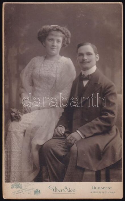cca 1910 Fiatal pár műtermi portréja, keményhátú fotó Uher Ödön budapesti műterméből, 21×13 cm