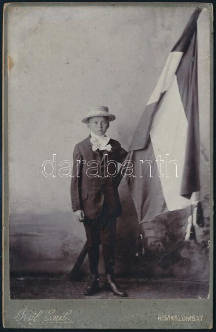 cca 1890 Rimaszombati (Felvidék) kisfiú díszruhában, nemzeti színű zászlóval, keményhátú fotó Reif Emil műterméből, 16,5×10,5 cm