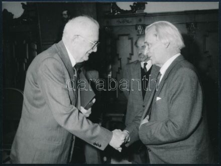 1989 szeptembere, Keresztury Dezső író, korábbi vallás- és közoktatásügyi miniszter és Straub F. Brunó, a Magyar Népköztársaság elnöke kezet fog egymással Keresztury Dezső 85. születésnapján, háttérben Berend T. Iván MTA