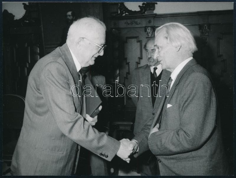 1989 szeptembere, Keresztury Dezső író, korábbi vallás- és közoktatásügyi miniszter és Straub F. Brunó, a Magyar Népköztársaság elnöke kezet fog egymással Keresztury Dezső 85. születésnapján, háttérben Berend T. Iván MTA