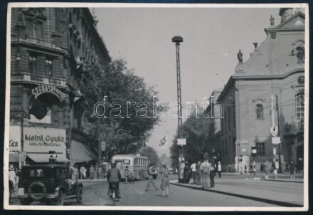 cca 1940 Ferenciek tere, Budapest, 7-es busz, Meinl Gyula üzlete és rekláma, Szénásy papírbolt, autómobil, kerékpáros, vintage fotó, jelzés nélkül, sarkaiban törésekkel, 8,5x12,5 cm