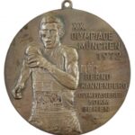 Németország 1977. 'XX. Olimpia, München, 1972. - Bernd Kannenberg - az 50km-es gyaloglás olimpiai bajnoka' kétoldalas, ezüstözött, festett bronz emlékérem füllel (80mm) T:2 kopott ezüstözés, ph Germany 1977. 'XX. Olympia, Munich,