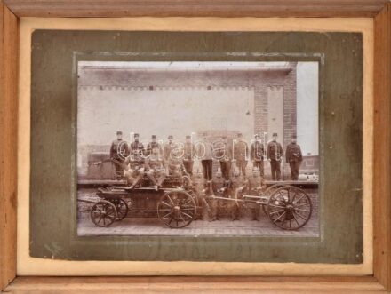 cca 1900 Tűzoltók csoportképe korabeli felszereléssel, egyiken kitüntetésekkel, háttérben háromnyelvű (magyar, német, szlovák?) táblával, Salgó Sándor (Budapest) hidegpecsétjével jelzett vintage fotója, kopásnyomokkal, kartonra