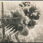 cca 1914-1918 Az Osztrák-Magyar Cs. és Kir. Haditengerészet (K.u.K. Kriegsmarine) dreadnought / pre-dreadnought csatahajója (Schlachtschiff), az elülső lövegtornyok ágyúinak sortüze, eredeti fotó, a hátoldalon feliratozva, egyik sarkán