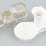 2 db asztali só- és borstartó: Zsolnay fehérmázas porcelán, jelzett, hajszálrepedéssel, h: 14 cm + üveg, elfordítható fedővel, h: 12,5 cm