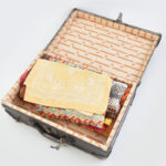 Régi bőrönd, kulccsal, korának megfelelő, viseltes állapotban, 39x27x13 cm + benne 4 db különféle méretű terítő, futó