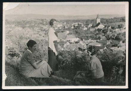 1936 Vízakna, Erdély, Szeben megye, a város látképe, előtérben fiatal hölgyekkel, hátoldalán feliratozott vintage fotó, bal szélén kissé sérült, 5,5x8 cm