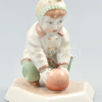 Zsolnay porcelán 'Labdás Öcsi'. Kézzel festett, jelzett (tervező: Sinkó András), egyik talpánál ragasztás nyomaival, m: 13 cm