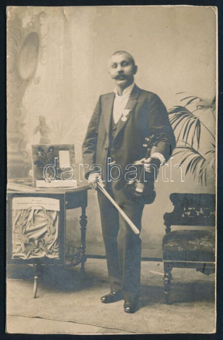 cca 1900 Czutor Béla 'Béla cigány' (1863-1909) cigányprímás, hegedűjével, díjaival ('Ezüst koszorú, Hódmezővásárhely város közönségének ajándéka Czutor Bélának'); keményhátú fotó, körbevágva, 14x9 cm