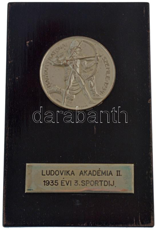 Manno Miltiadesz (1879-1935) 1934. 'Magyar Katonai Szemle' fém lemezérem fa posztamensen, gravírozott 'LUDOVIKA AKADÉMIA II. 1935. ÉVI SPORTDÍJ' lapkával (51mm) T:AU