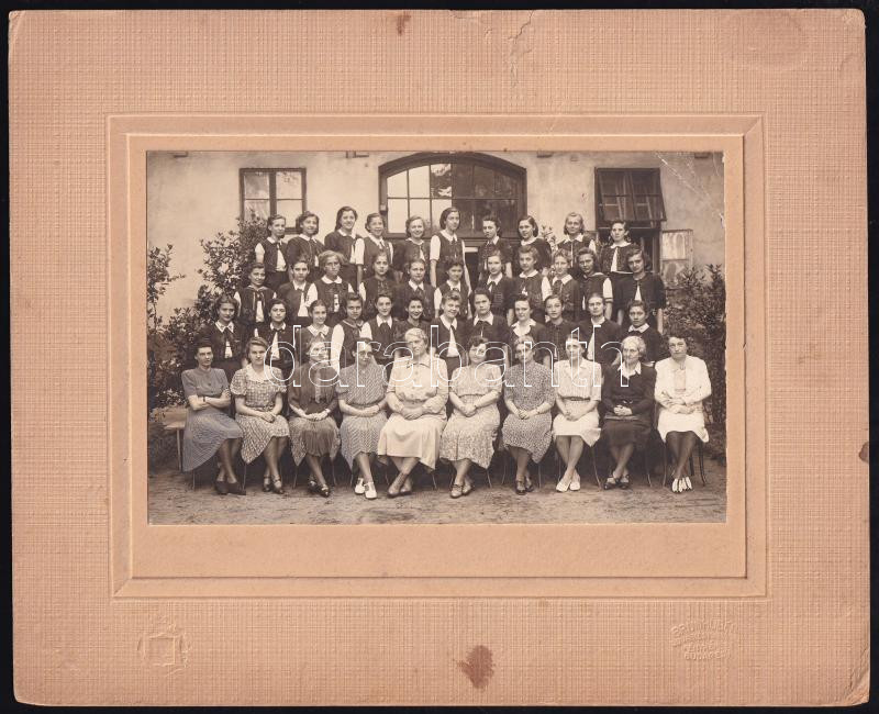 cca 1920-1940 Lányiskolai csoportkép (VIII. ker. Práter u. Községi Polgári Leányiskola), kartonra kasírozott fotó, jelzett (Brunhuber udv. és kam. fényképész, Bp.), hátoldalán a képen szereplők névsora, a kartonon sérüléssel,