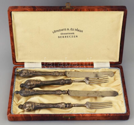 Ezüst (Ag) nyelű 2db villa és 2 db kés, dobozában, jelzett: Löfkovits és Társa Debrecen, korának megfelelő állapotban. 1900 körül. A tétel a Gödöllői Királyi Kastélyban tekinthető meg. A megtekintéshez időpontot kell