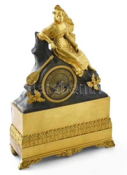 Empire kandallóóra. Franciaország XIX. sz. eleje. Tűziaranyozott bronz, legyezőt tartó női alakkal, külön mandolinnal. Ingajáratos, felesütős szerkezet, szervizelt működő, esztétikailag is hibátlan állapotban. A csengő igazításra szorul m: 38 cm sz: 26,5